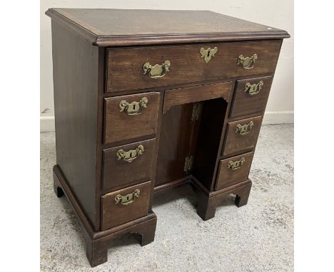 An 18th Century mahogany kneehole desk with adapted fall front secretaire drawer with pigeon holes and drawers, over a centra