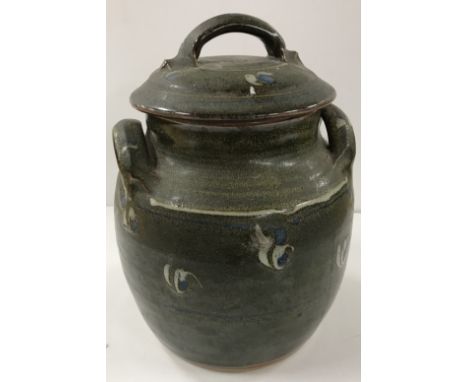 A Winchcombe Pottery glazed jar and cover with eye type decoration on a mottled green ground bearing pottery stamp to bottom 