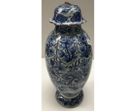 A Chinese Kangxi blue and white ovoid vase and cover, decorated throughout with scrolling foliage and flowers and lotus leaf 