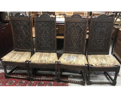 A set of four oak and inlaid high back chairs in the 17th Century manner, the carved lozenge panelled backs with grape and vi