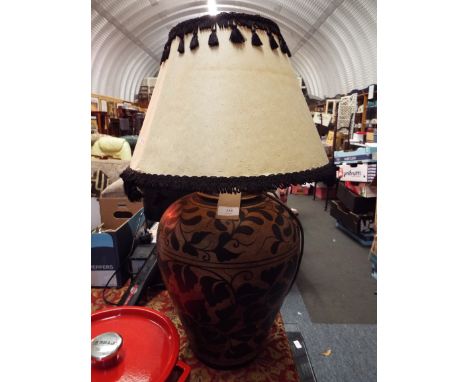 A large floral decorated terracotta table lamp and shade