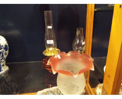 A Duplex cranberry glass oil lamp plus another together with a cranberry and frosted glass shade 