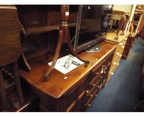 A dark Ercol dresser two plate racks above four short central drawers flanked by two cupboards 