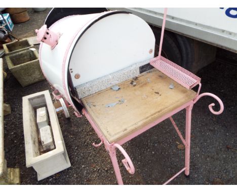 A portable pink and white enamel drum BBQ