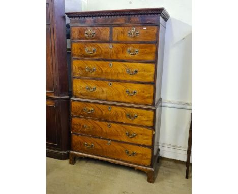 George III mahogany flame veneer 8 drawer tallboy with Greek key and dental pediment, later brasswork upon bracket feet.