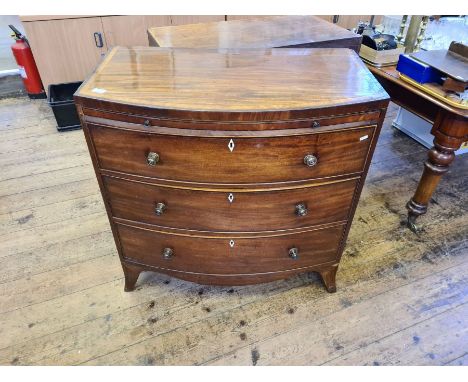 Regency mahogany bow fronted 3 drawer chest with crossbanded top and brushing slide upon splayed bracket feet.