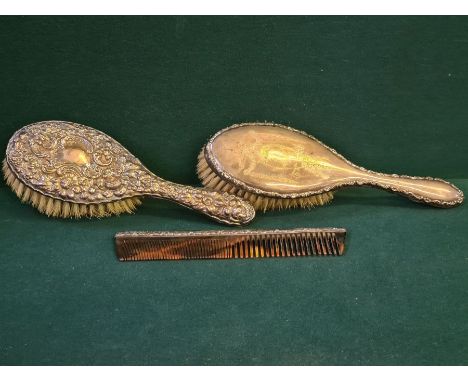 2 silver backed ladies hairbrushes decorated with ribbons and garlands and embossed flowers and scrolls together with a faux 