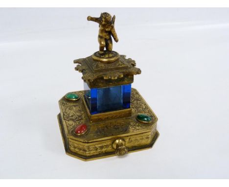 Victorian gilt metal and blue glass desk glue pot, the brush with cherub finial, the chamfered square base with drawer for st