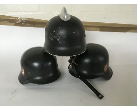 A group of three helmets including two German steel helmets and one possibly a medic style helmet.