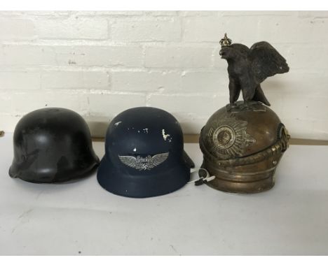 A group of three German helmets including a standard steel helm, one bearing a “Luftschutz” decal and a pickelhaube style hel