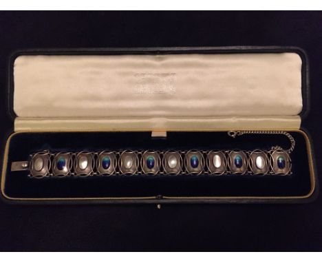 An enamel and mother-of-pearl bracelet, the interlocking oval links set to centre with alternating discs of blue/green enamel