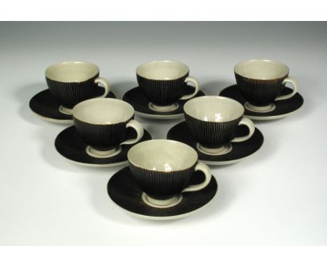 § Dame Lucie Rie (Austrian/British, 1902-1995), a set of six stoneware cups and saucers, with manganese glaze and vertical sg