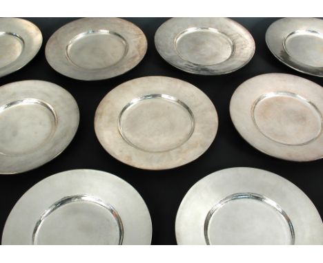 Twelve George V and Edward VIII silver dinner plates by Omar Ramsden, London, 1932, 1933 and 1936, each of plain plannished f