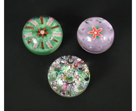 Two Paul Ysart floral paperweights, one to a purple ground with bubble surround, the other with aventurine enhanced flower he