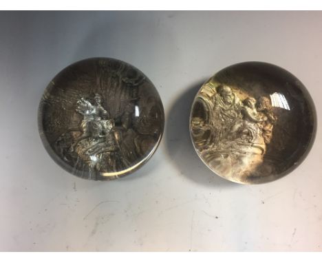 Two 19th century pinchbeck glass paperweights, each with silver metal scenes in relief, one mounted to a marble base (2)  