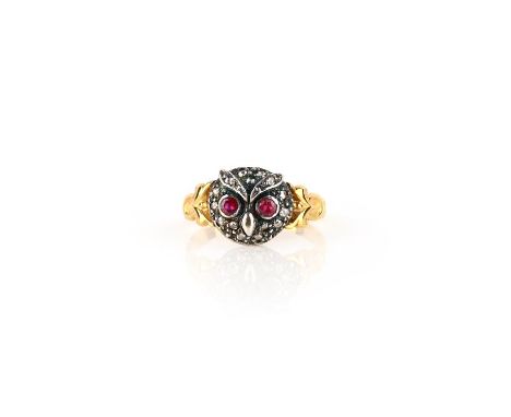 A ruby and diamond ring, designed as an owl's face, set with rose-cut diamonds and circular-cut rubies, to gold scroll should