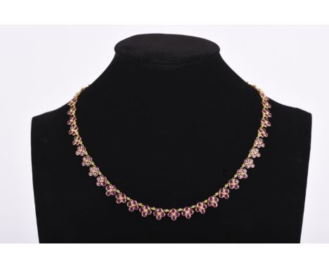 A ruby necklace, composed of links quatrefoil links spectacle-set with circular-cut rubies, length 40.5cm, stamped 18K