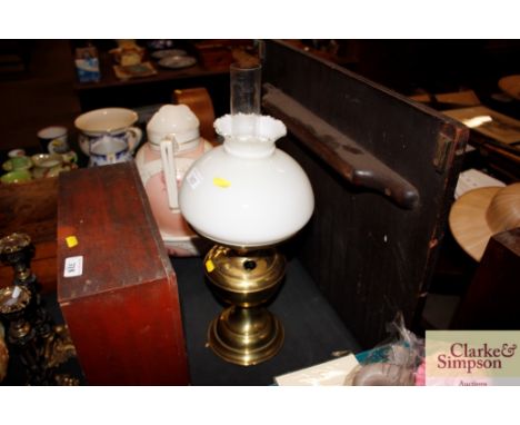 A brass oil lamp with opaque glass shade 