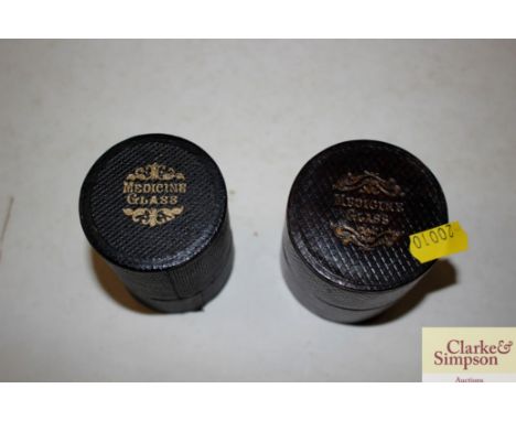 Two vintage measuring glasses in leather cases 