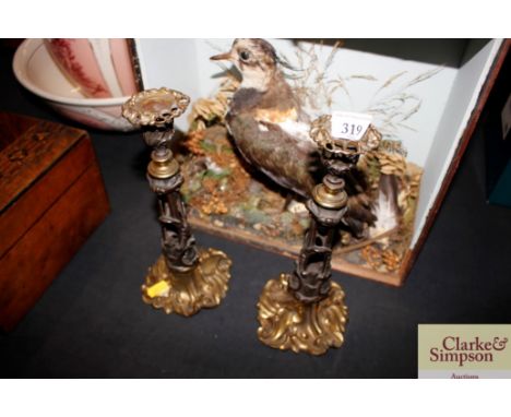 A pair of ornate bronze and gilt metal candlesticks 