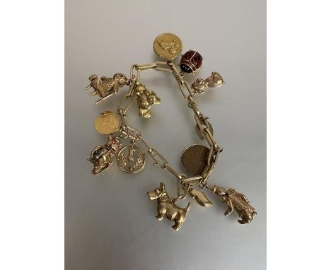 A 14ct gold chainlink charm bracelet suspending a quantity of 9ct and yellow metal charms, the chain stamped "585", the thirt