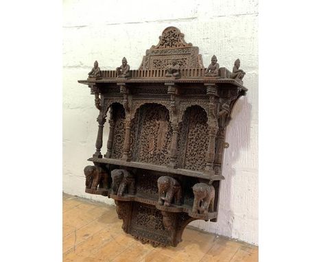 An Anglo-Indian open wall shelf, early 20th century, profusely carved with figures and pierced interlaced foliage, the arcade