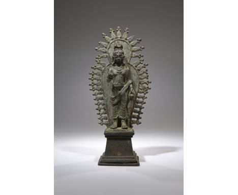 BronzeKashmir , 12th centuryDimensions: Height 19 cm Wide 9 cm Depth 6 cmWeight: 619 gramsBronze Buddha standing on tall podi