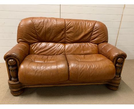 A leather two seater sofa (H95cm W140cm D80cm)