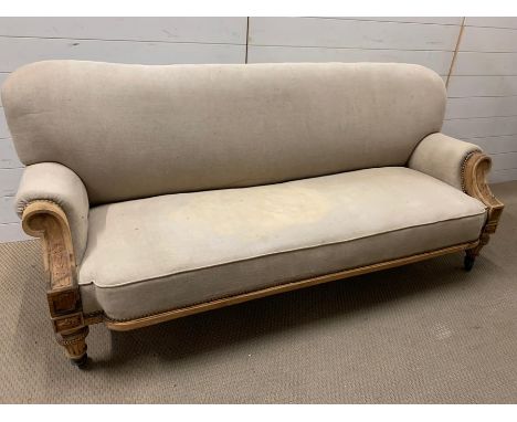 A three seater sofa with carved ends and castors (H83cm W180cm D60cm)