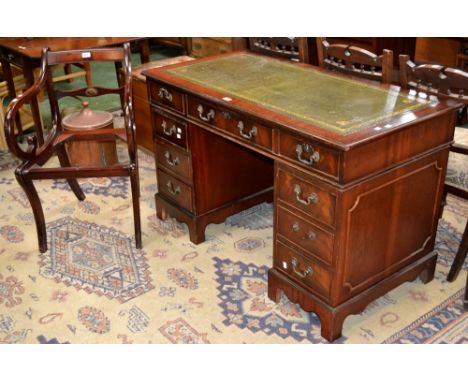 A reproduction mahogany pedestal desk, leather inlaid top, one long drawer and two short to frieze, kneehole flanked by three