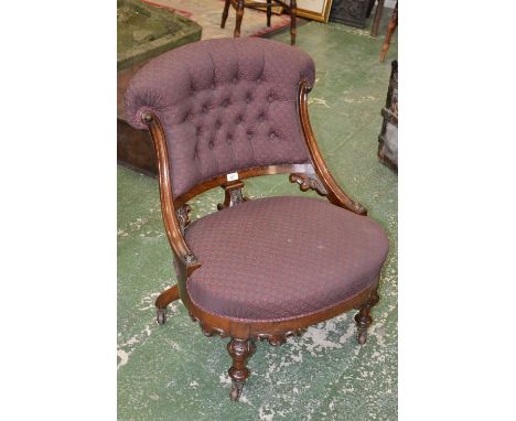 A Victorian walnut salon tub chair, button back, stuffed-over upholstery, turned legs carved with scrolling acanthus, ceramic