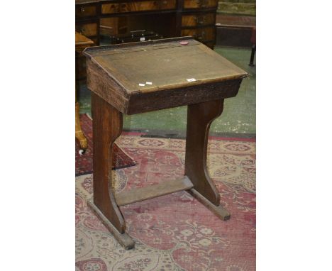 An oak school desk with coral pink ceramic liner to ink well.