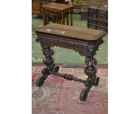 A Victorian 'Jacobethan' canted rectangular oak card table, folding top with acanthus edge enclosing a baize-lined playing su