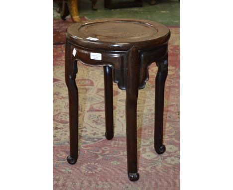 A Chinese padouk wood circular jardiniere stand, panelled top above a shaped frieze, scroll feet, 52cm high, 36cm diam, early