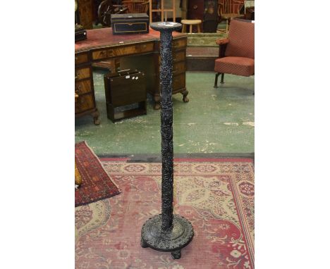 A Chinese bamboo floor standing pricket candle stick, circular top with iron spike, the column pierced and profusely carved w