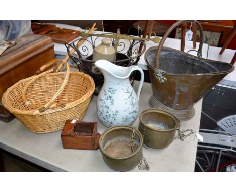 A wrought iron decorative log basket; a copper helmet coal scuttle; a brass hanging scale; a metal cauldron; etc.