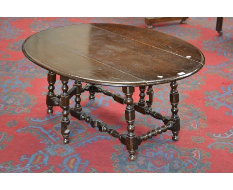 An Ercol type dark elm oval dropleaf coffee table