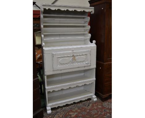 An unusual Swedish painted pine dresser, shaped cornice and uprights, three shelves to top, projecting base with fall front e