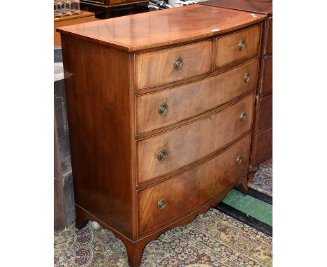 A reproduction bow fronted chest, crossbanded top, two short cockbeaded drawers over three graduated long, brass loop handles