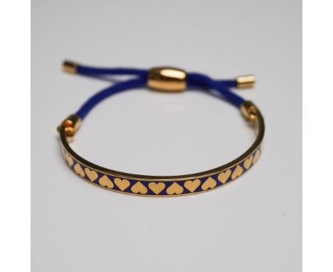 Halcyon Days enamel and cord bracelet featuring a gold-plated half-bangle with a deep blue enamel inlay adorned with a repeat