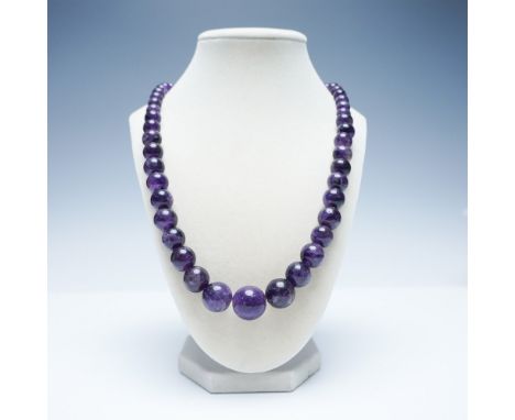 This elegant amethyst bead necklace features a graduated strand of polished, deep purple amethyst beads, ranging in size with