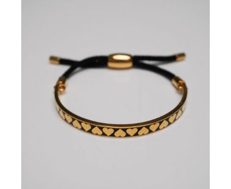 Halcyon Days enamel and cord bracelet featuring a gold-plated half-bangle with a sleek black enamel inlay adorned with a repe