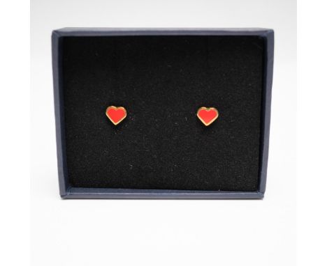 A pair of Halcyon Days red heart stud earrings, featuring gold-tone metal frames with vibrant red enamel hearts. These delica