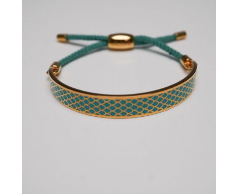 Halcyon Days gold-plated enamel bracelet featuring an intricate fish scale pattern in gold and teal tones. The bangle-style b