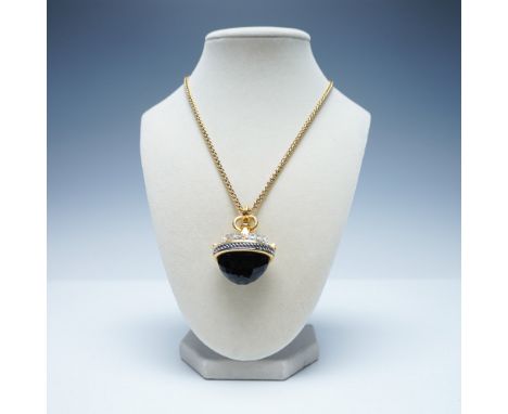 A striking gold-tone necklace by Joan Rivers, featuring a faceted black stone encased in an ornate, rhinestone-studded pendan