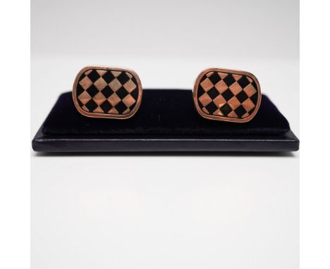 A refined pair of Halcyon Days checkered enamel cufflinks, featuring a black and copper-toned harlequin pattern set in a rose