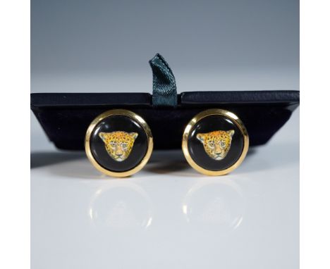 A pair of Halcyon Days gold-plated enamel cufflinks featuring a striking leopard motif against a black enamel background. The