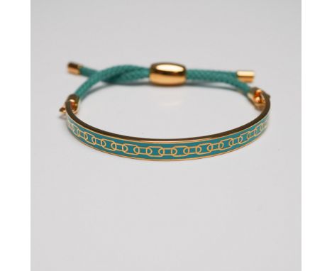 Halcyon Days gold-plated bracelet featuring a sleek half-bangle design with an intricate teal enamel pattern. The bracelet is