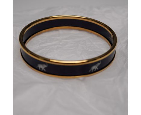 Halcyon Days enamel bangle featuring a deep navy enamel background accented with a repeating elephant motif. The bracelet is 