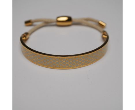 Halcyon Days gold-plated enamel bracelet featuring an intricate fish scale pattern in gold and cream tones. The bangle-style 